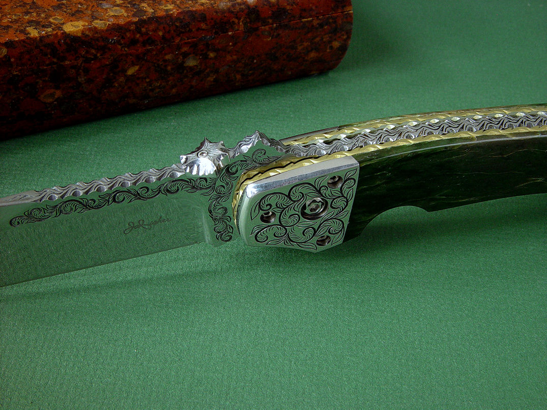 "Procyon" liner lock folding knife, obverse side view,in hand-engraved ATS-34 high molybdenum stainless steel blade, hand-engraved 304 stainless steel bolsters, anodized 6AL4V titanium liners and lockplate, Pounamu New Zealand Greenstone Nephrite Jade gemstone handle, case of Granite, Quartz Terrazzo composite