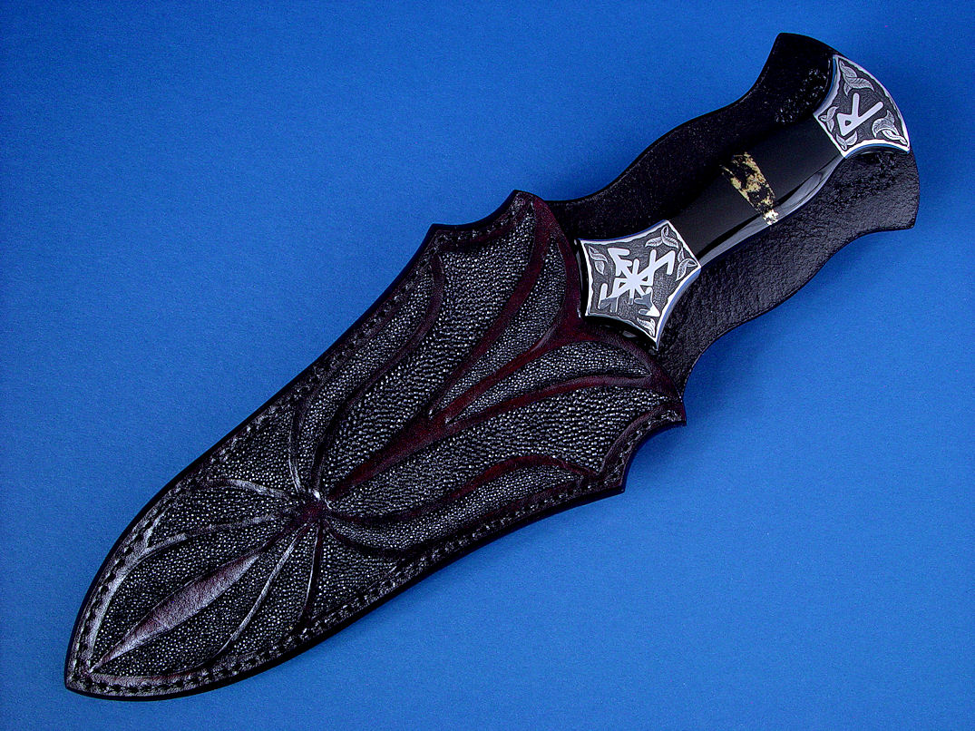 "Vesta" Dagger, obverse side view in hot-blued O1 high carbon tungsten-vanadium tool steel blade, hand-engraved 304 stainless steel bolsters, Australian Black Jade and Apache Gold (chrysopyrite and slate) gemstone handle, hand-carved leather sheath inlaid with stingray skin