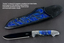 "Carina" obverse side view in mirror polished and hot-blued O1 high carbon tungsten-vanadium tool steel blade, hand-engraved 304 stainless steel bolsters, Labradorite gemstone handle, hand-carved, hand-dyed leather sheath