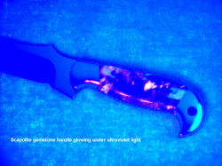 Scaoplite gemstone handle glowing under ultraviolet light source